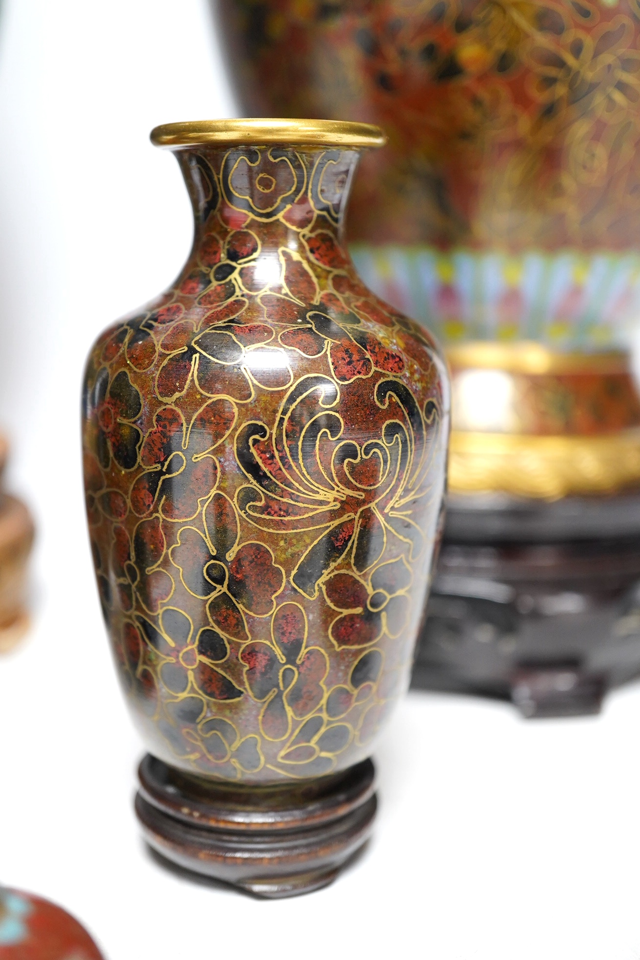 Two large Chinese cloisonné vases with hardwood stands, a smaller pair of vases, a pair of similar boxes and covers and a small table bell, tallest 31cm. Condition - fair to good